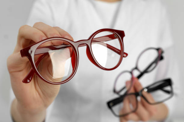 Woman with different glasses on light background, closeup