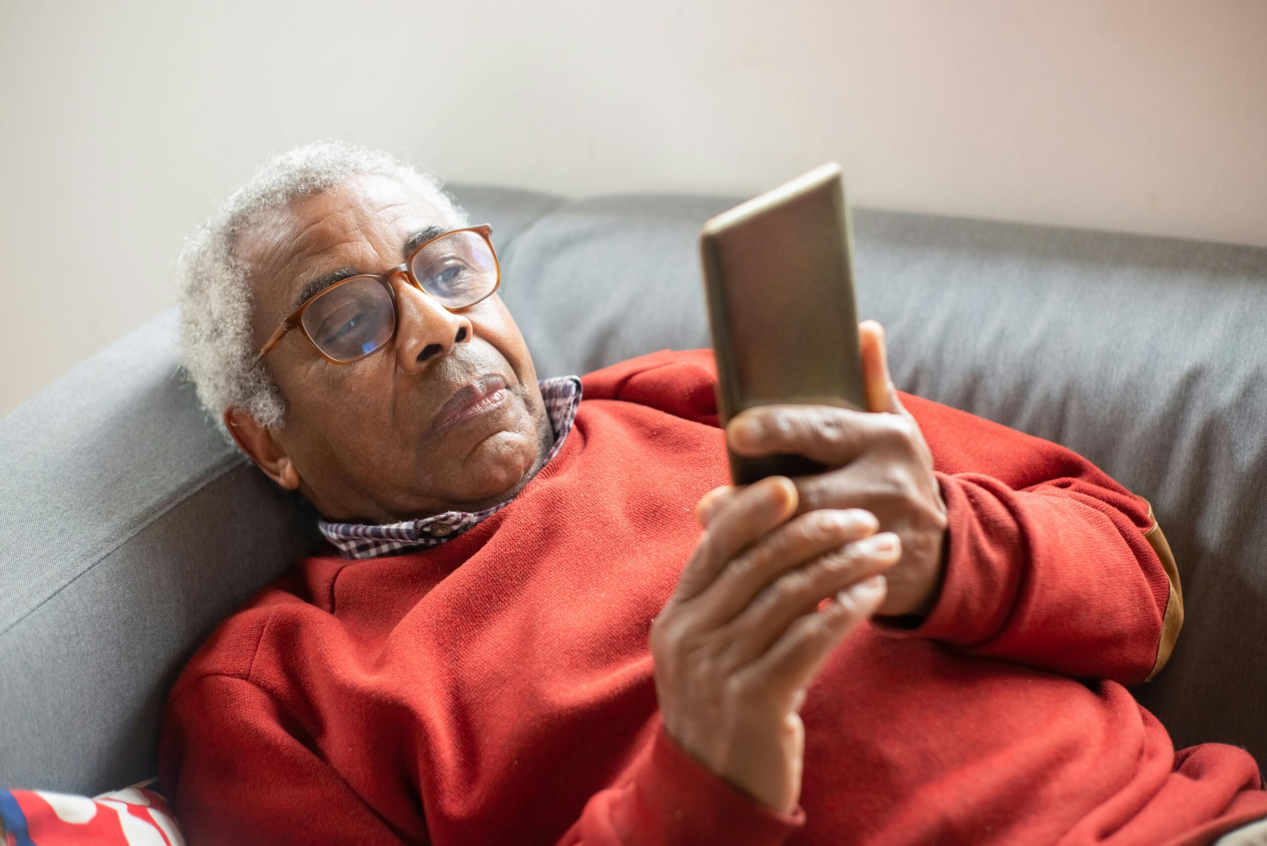 senior person on phone with reading glasses